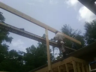 Carpenter setting a ridge beam over a new addition frame — Ice Dam Removal by Roofing Brothers in Plain