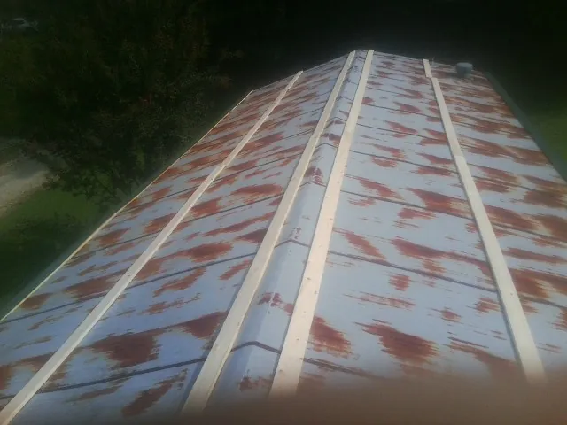 Rusted metal roof panels with new wood purlins before replacement — Storm Damage Roof Repair in Plain by Roofing Brothers