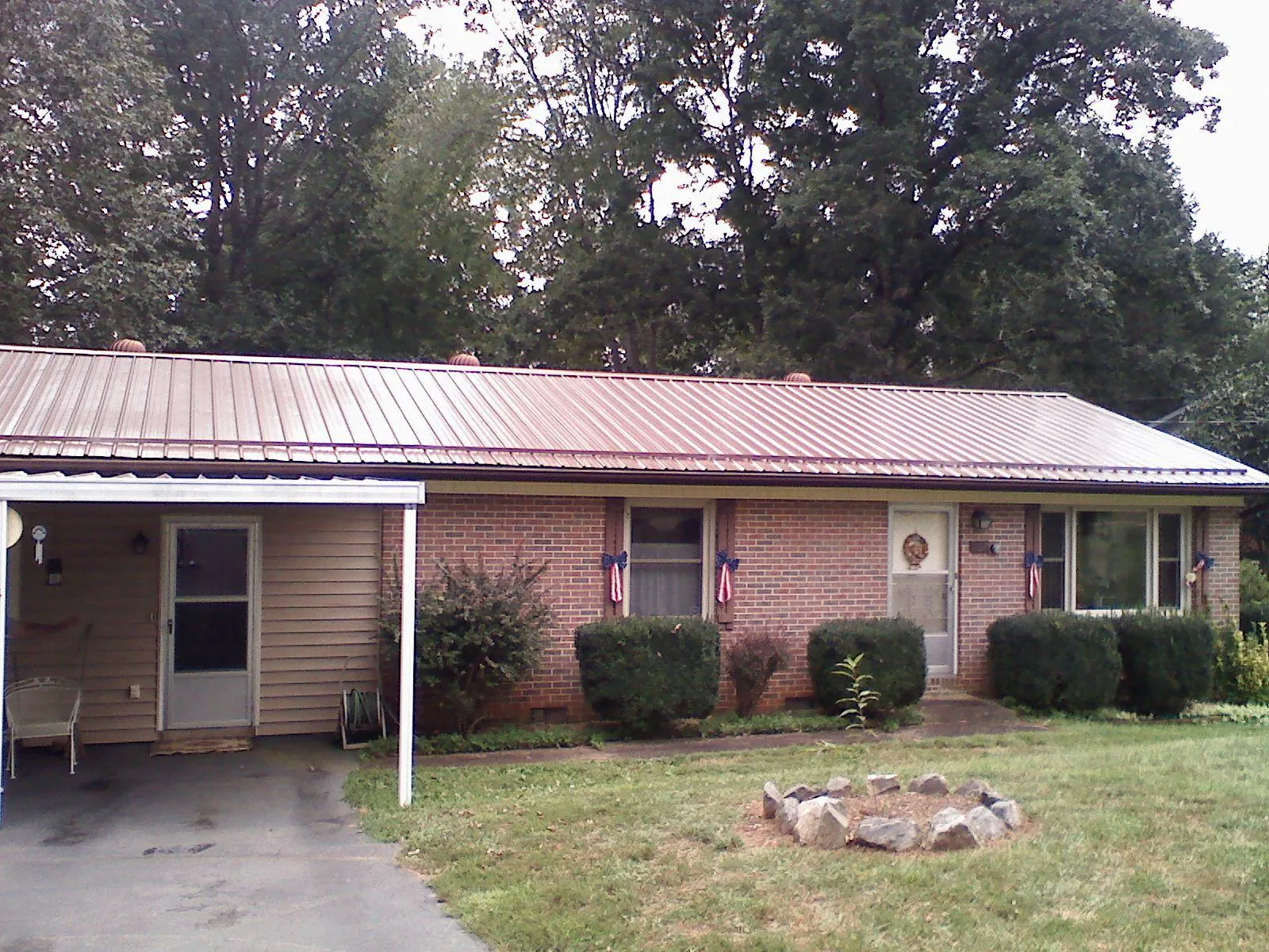 Bronze metal roof and carport on a brick ranch home — Roof Repair work by our crew in Plain